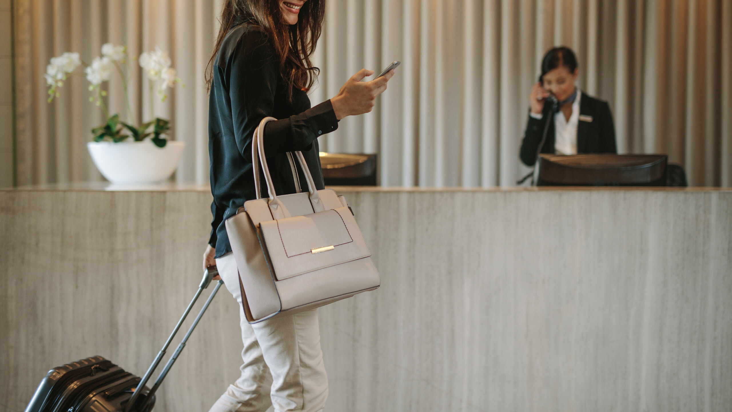 Business traveler in hotel hallway with phone